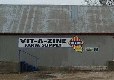A sign on the side of a building advertising vit-a-zine farm supply.