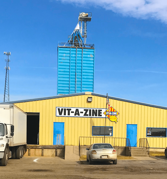A truck parked in front of a building with a sign on it.