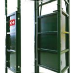 A green metal structure with two doors and three red arrows.